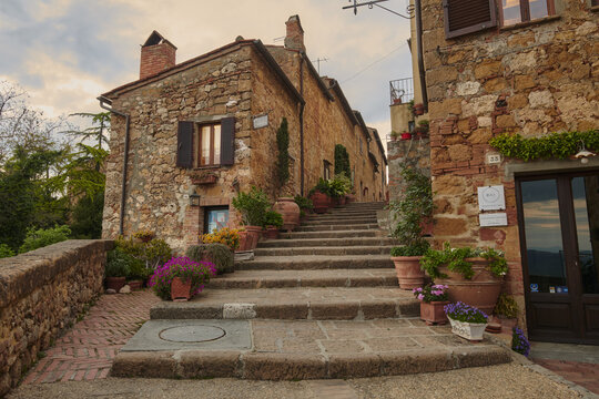Pienza, Tuscany, Italy - 01 May 2022: View of a charming stone staircase lined with terracotta flower pots in the historic town of Pienza, Tuscany, Italy.