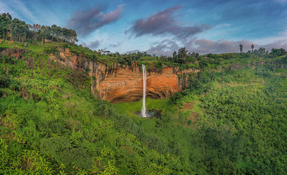 Aerial view of Sipi Falls cascading down a dramatic cliff face surrounded by lush green banana plantations and dense vegetation in Kapchorwa, Eastern Region, Uganda.