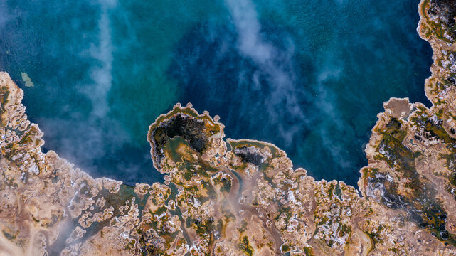 Aerial view of the Sempaya Hot Springs in Semuliki National Park with steaming geothermal pools and mineral deposits surrounded by lush vegetation in Bundibugyo, Western Region, Uganda.
