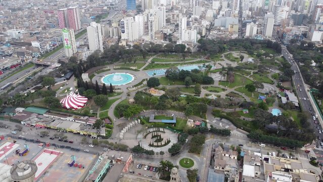 Aerial view of Parque de la Reserva featuring its iconic fountains, lush green gardens, and surrounding urban architecture in Lima, Lima, Peru.