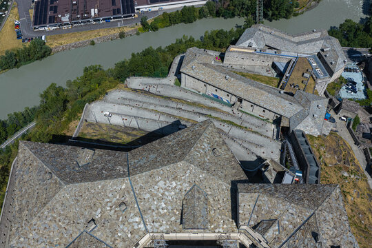 Aerial view of Forte di Bard with its stone rooftops, winding paths, and surrounding landscape in Bard, Valle d'Aosta, Italy.