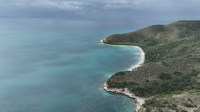 Aerial view of Playa Blanca with turquoise waters, rocky cliffs, and lush vegetation along the coastline in Azua, Azua Province, Dominican Republic.