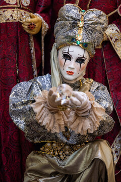 Riquewihr, France - 04 July 2026: View of a person wearing an elaborate Venetian-style mask and ornate costume holding a crystal ball during a festival.