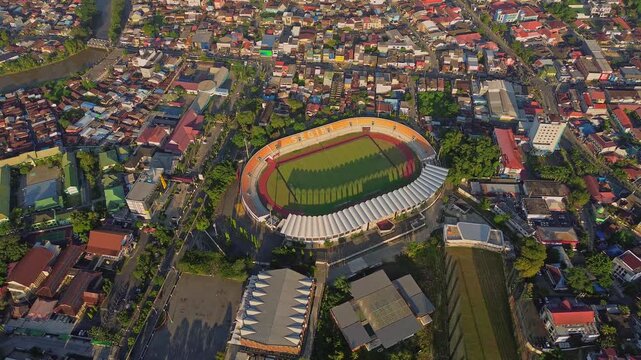 Aerial view of Segiri Stadium with its oval track and seating surrounded by the dense urban landscape of Samarinda, East Kalimantan, Indonesia.