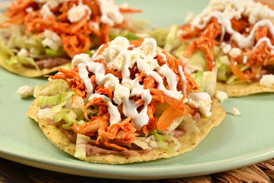Fresh Mexican tinga de pollo, tostadas with beans, lettuce and cream