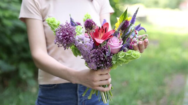 Woman with bouquet of beautiful summer flowers outdoors, closeup
