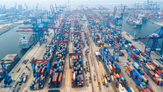Jakarta, Indonesia - 18 July 2026: Aerial view of Port of Tanjung Priok with rows of colorful shipping containers, large gantry cranes, and cargo ships docked in the harbor.