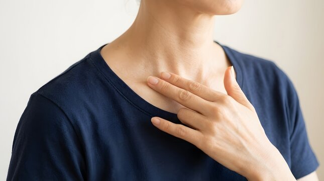鎖骨付近を指先で優しくマッサージする女性のデコルテ