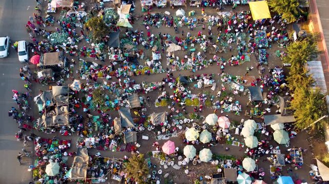 Aerial view of the bustling Kimana market with colorful umbrellas, numerous stalls, and crowds of people trading goods in Kimana, Kajiado County, Kenya.