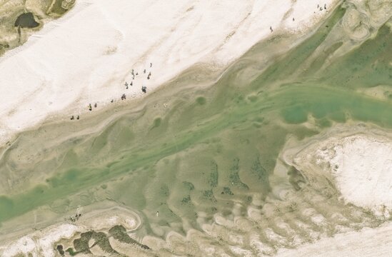 Aerial view of the river with sandbanks and people walking along the shore in Gaibandha, Rangpur Division, Bangladesh.
