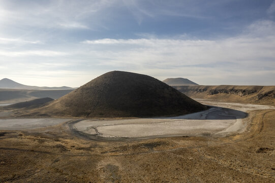 Aerial view of Lake Meke, a volcanic crater lake with a central cone surrounded by arid terrain and dry lake beds in Karapinar, Konya, Turkiye.