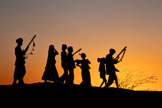 Rajasthan, India - March 1986: View of traditional musicians walking through the Rajasthan desert