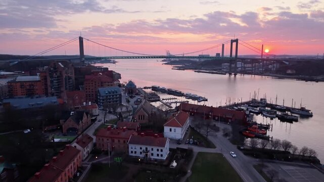 Aerial view of Alvsborg Bridge over Gota Alv river at sunset with urban waterfront and calm water in Gothenburg, Vastra Gotaland, Sweden.
