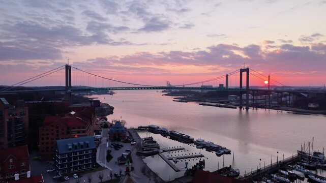 Aerial view of Alvsborg Bridge spanning the Gota Alv river at sunset with calm water and city harbor structures in Gothenburg, Vastra Gotaland County, Sweden.