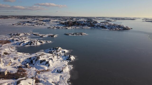 Aerial view of Stora Amundon, a snowy coastal landscape with frozen waters and rocky islands in Hovas, Vastra Gotalands lan, Sweden.