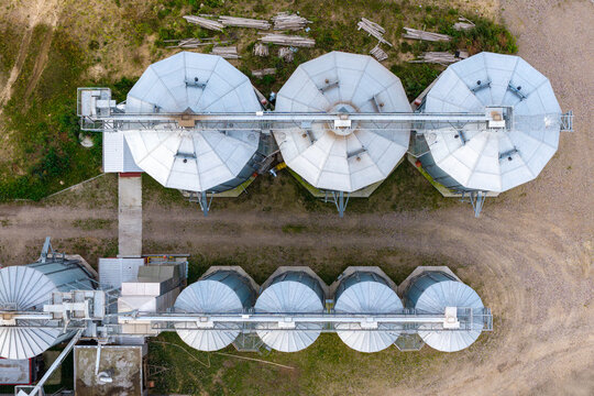 Aerial view of grain bins arranged in rows at a rural agricultural facility in Poland.