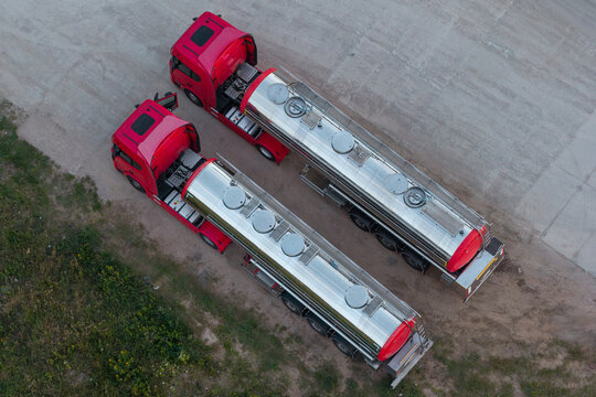 Aerial view of two red tanker trucks parked side-by-side on a paved surface in Poland.