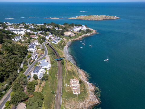 Aerial view of the Dalkey coastline featuring the historic EIRE sign, railway tracks, coastal houses, and boats in the Irish Sea in Dublin, County Dublin, Ireland.