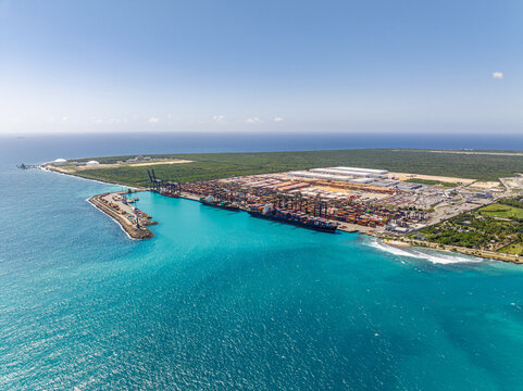 Aerial view of DP World Dominicana port facility with container ships, cranes, and shipping containers along the turquoise Caribbean coast in Boca Chica, Santo Domingo, Dominican Republic.