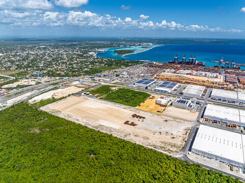 Aerial view of DP World Dominicana port facility with shipping containers, industrial warehouses, and coastal landscape in Boca Chica, Santo Domingo, Dominican Republic.