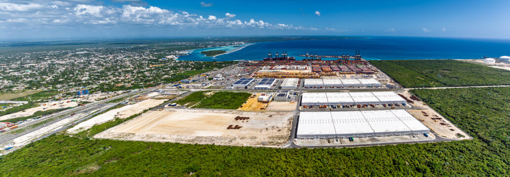 Aerial view of the DP World Dominicana port facility featuring shipping containers, industrial warehouses, cranes, and coastal infrastructure in Boca Chica, Santo Domingo, Dominican Republic.