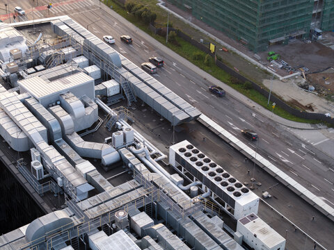 Aerial view of an AI data center rooftop featuring extensive HVAC ventilation systems and cooling units, located next to a busy road with moving cars in Krakow, Lesser Poland Voivode, Poland.