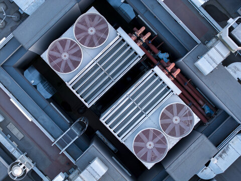 Aerial view of industrial cooling fans on a data center rooftop with metal pipes and ventilation systems in Krakow, Lesser Poland Voivode, Poland.