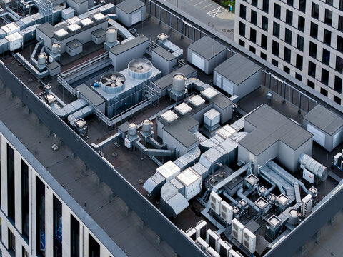 Aerial view of the rooftop of a modern office building featuring extensive HVAC systems, ventilation ducts, and cooling units in Krakow, Lesser Poland Voivode, Poland.