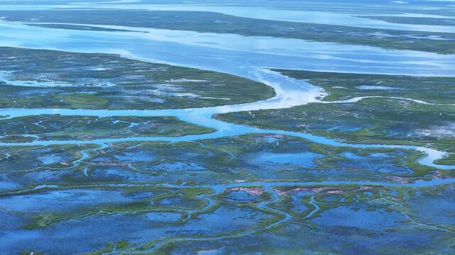 Aerial view of winding tidal creeks and lush green marshland at Jekyll Island, Georgia, United States.