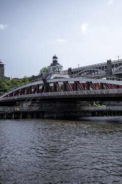 View of the historic Swing Bridge with its red steel structure and central control tower spanning the River Tyne in Newcastle upon Tyne, England, United Kingdom.