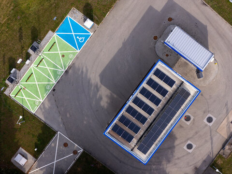 Aerial view of a modern Electric Vehicle Charging Station with Solar Roof, Representing Sustainable Transportation and Smart City Infrastructure