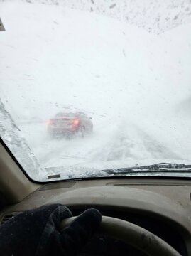 Driving through blizzard whiteout on frozen road
