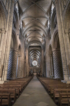 View of the interior of Durham Cathedral with its iconic Norman architecture, ribbed vaulted ceilings, and rows of wooden pews in Durham, England, United Kingdom.
