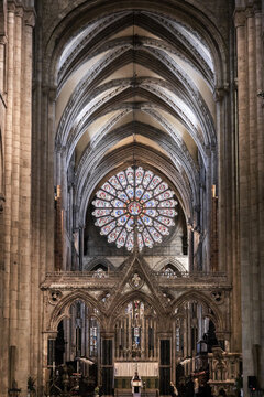 View of the interior of Durham Cathedral with its intricate rose window, vaulted stone ceilings, and ornate gothic architecture in Durham, England, United Kingdom.