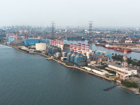 Kecamatan Pademangan, Indonesia - 19 July 2026: Aerial view of Tanjung Priok Power Plant with its red and white chimneys, industrial infrastructure, and storage tanks along the coast.