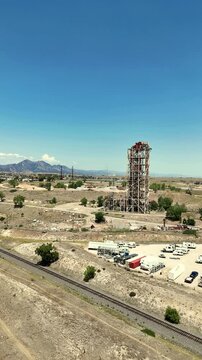 Aerial view of the historic Leyden coal mine headframe surrounded by arid landscape, railroad tracks, and an RV park in Jefferson County, Colorado, United States.