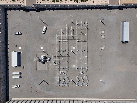 Aerial view of an electrical substation with transformers and electrical equipment on a gravel lot in Thornton, Colorado, United States.