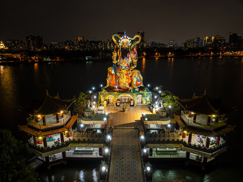 Aerial view of the illuminated Pei Chi Pavilion statue at Lotus Pond, featuring traditional temple architecture and vibrant night lights in Kaohsiung, Taiwan.