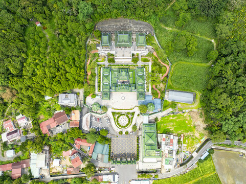 Aerial view of the Chung Tai Chan Monastery with its distinctive green tiled roofs, symmetrical courtyards, and surrounding lush forest in Puli Township, Nantou County, Taiwan.