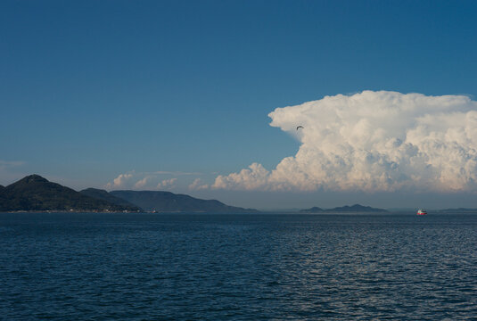 Scenic summer ocean landscape of Setouchi islands with a bird and giant cumulus