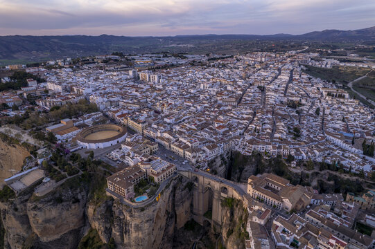 Aerial view of the historic town of Ronda, featuring the iconic Puente Nuevo bridge spanning the El Tajo gorge, the bullring, and white-washed buildings in Ronda, Andalusia, Spain.