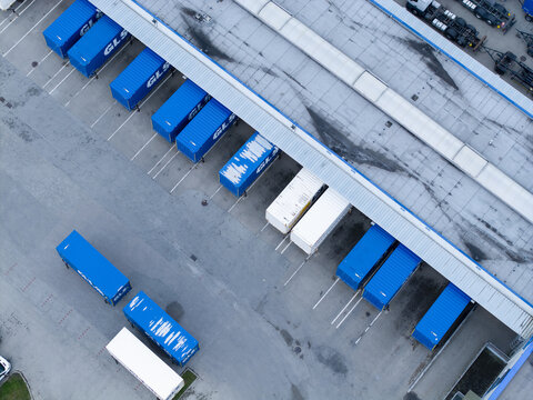 Skawina, Poland - 19 July 2026: Aerial view of the GLS Curier sorting centre, showing blue shipping containers parked at the loading bays of a large industrial warehouse facility.