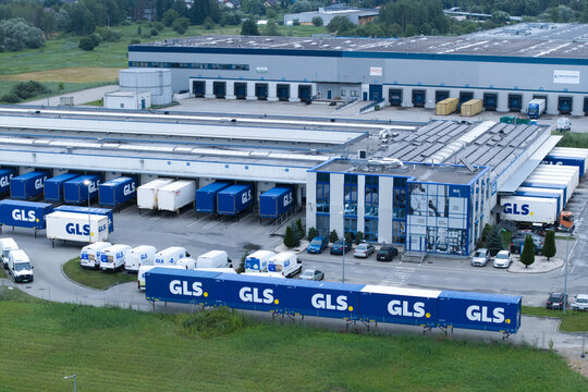 Skawina, Poland - 19 July 2026: Aerial view of the GLS courier sorting centre featuring numerous blue shipping containers, delivery trucks, and the large industrial facility building.