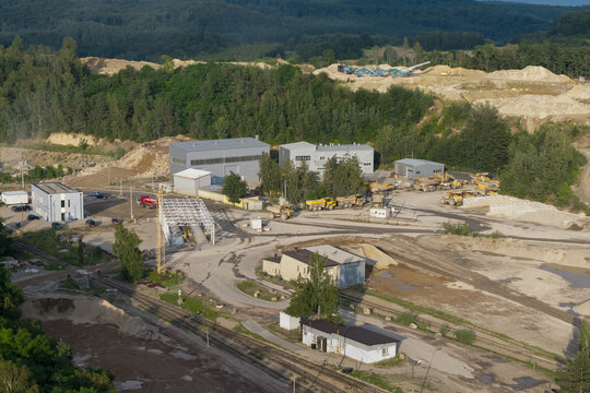 Aerial view of the kopalnia porfiru i diabazu quarry featuring industrial buildings, heavy machinery, and trucks surrounded by lush forest in Krakow, Lesser Poland Voivode, Poland.
