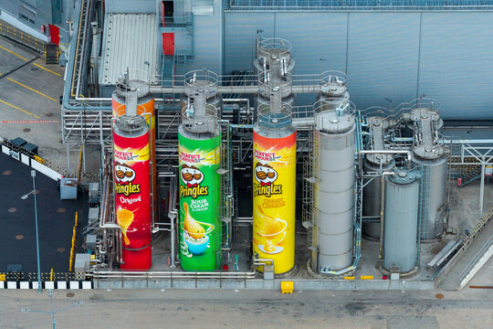 Kutno, Poland - 19 July 2026: Aerial view of the Pringles potato chips factory with large colorful storage silos featuring iconic branding and industrial piping at the manufacturing facility.