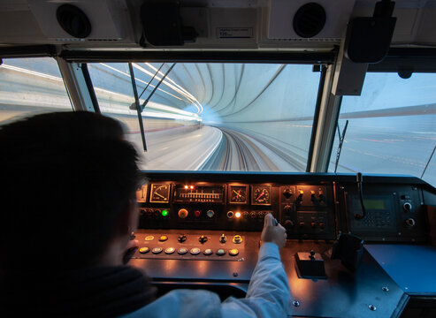 View of a train driver operating a train inside the tunnel at Amsterdam Airport Schiphol with motion blur on the tunnel walls Schiphol, Noord-Holland, Netherlands.