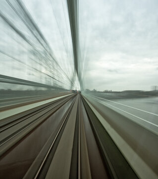 View of a train moving across a bridge with motion blur effect over the urban landscape in Utrecht, Utrecht, Netherlands.