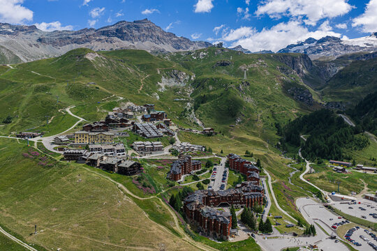 Aerial view of the alpine village of Breuil-Cervinia nestled in green mountain slopes, featuring traditional architecture and winding roads in Breuil-Cervinia, Aosta Valley, Italy.