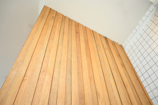 modern exterior wall featuring vertical wooden panel and white tile cladding
