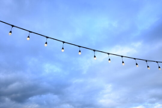 decorative string light hanging outdoors under a clear daylight sky